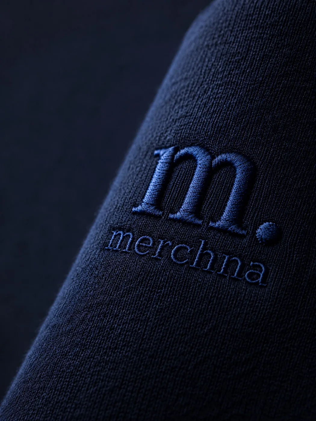 The Merchna logo embroidered on navy fabric